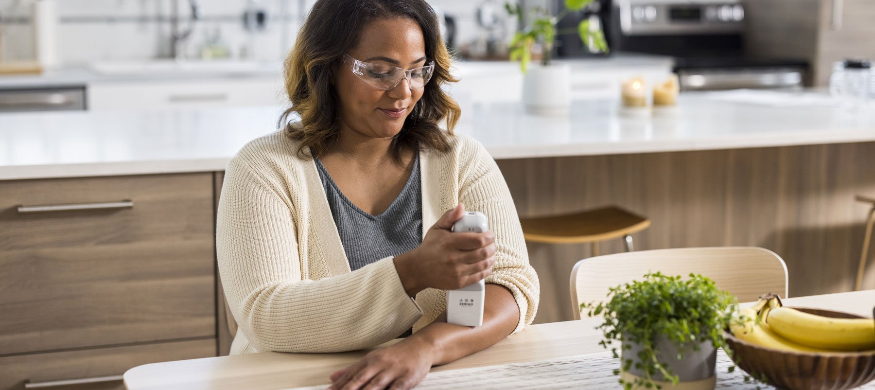 Female holds Zerigo Health Light Device in Kitchen